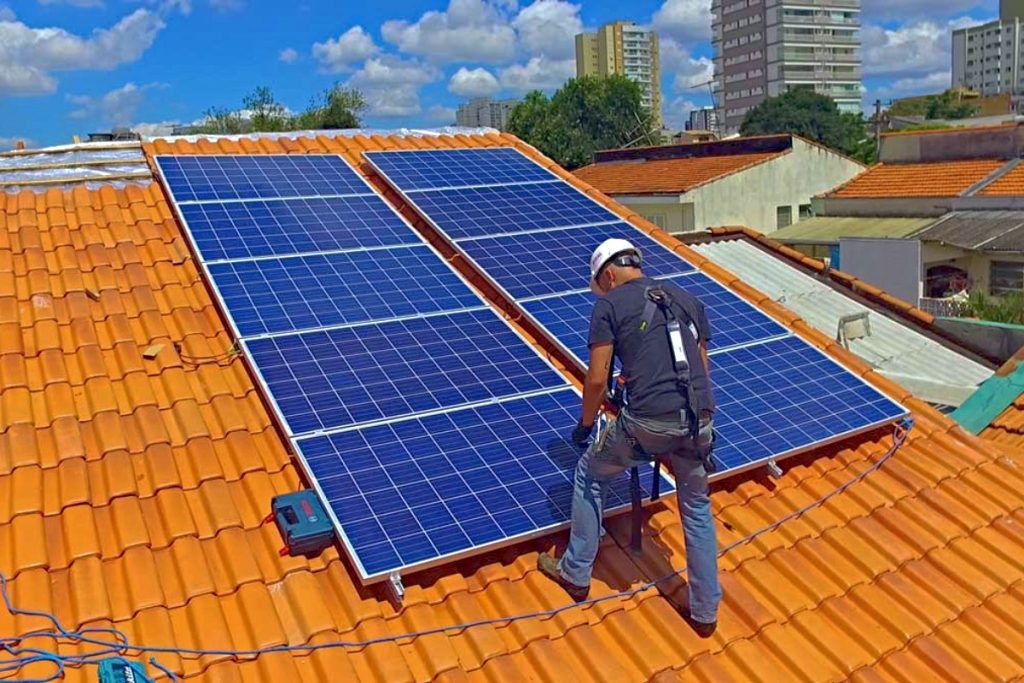 homem instalando painéis fotovoltaicos