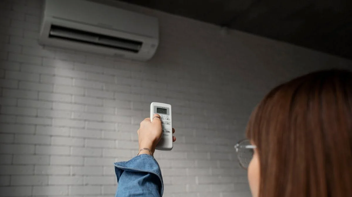 mulher utilizando um modelo de ar-condicionado que consome menos energia