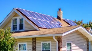 Casa com painéis solares no telhado e céu azul