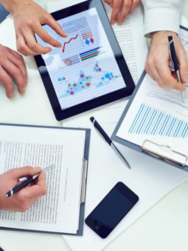 mesa com pessoas papelada e tablet