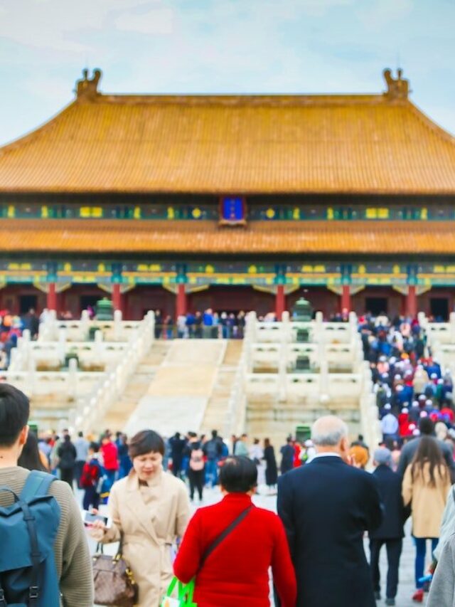 Templo com pessoas visitando e mulher posando para foto