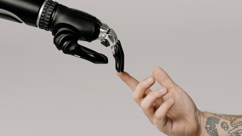 mão de robô tocando mão humana