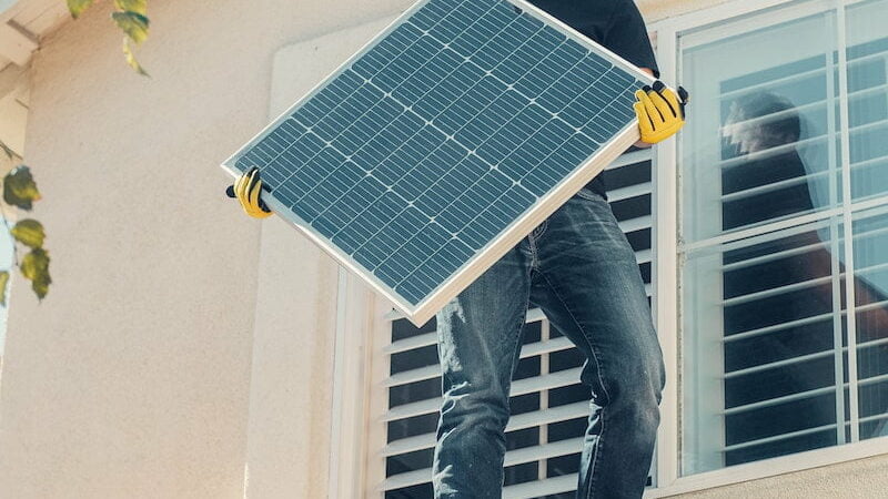 Integrador segurando painel fotovoltaico.